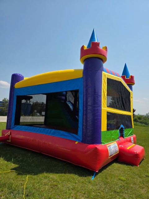 Castle-style bounce house with turrets in red, yellow, blue, and purple